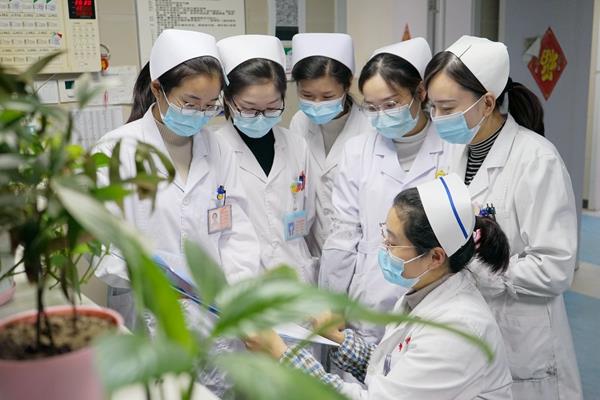 护士长陈英翠与同事们讨论护理病历的书写600.jpg 护士长陈英翠与同事们讨论护理病历的书写600.jpg